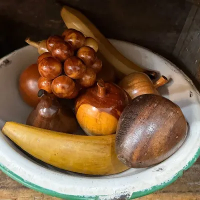 Bowl of carved wooden fruit in enamelware bowl
