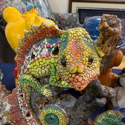 Colorful mosaic chameleon sculpture on branch