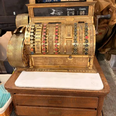 Antique brass cash register on oak marble-top base