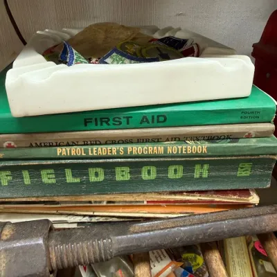 Boy Scout Fieldbook and First Aid books with patch-filled ashtray