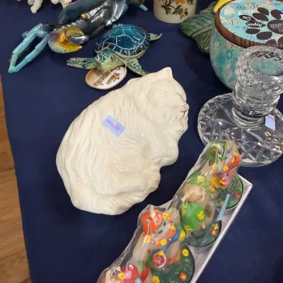White ceramic sleeping cat with sea life figurines