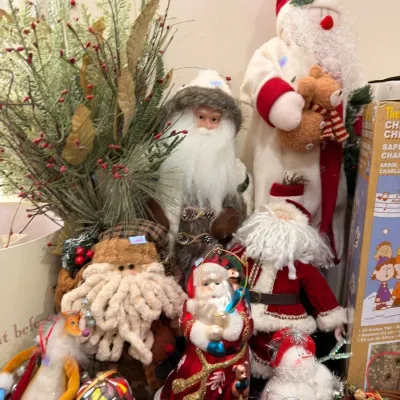 Collection of Santa Claus figures and holiday greenery