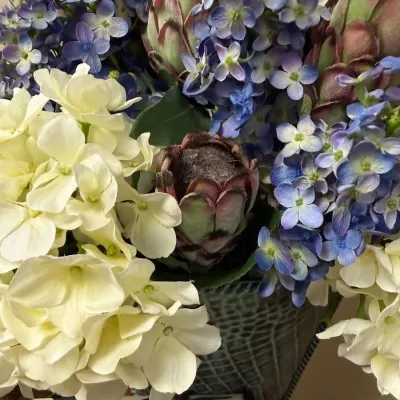 Silk hydrangea and protea arrangement in verdigris planter