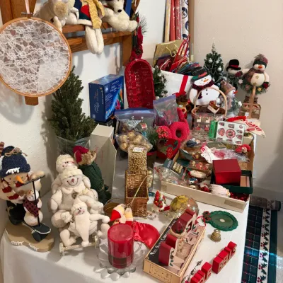 Sale Photo Thumbnail #78: Assortment of vintage and contemporary Christmas decorations, including plush snowman figurines, miniature artificial trees, wrapping paper, and various holiday ornaments.