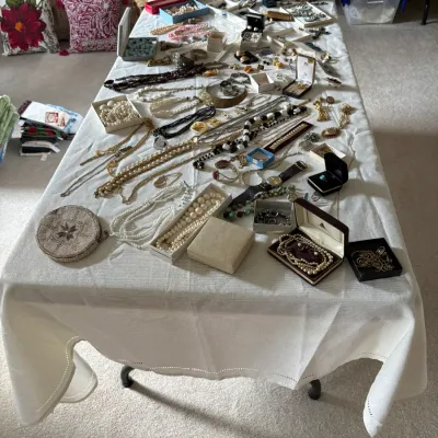 Sale Photo Thumbnail #10: Large collection of vintage costume jewelry, including pearl necklaces, beaded strands, gold-tone chains, brooches, and boxed sets.