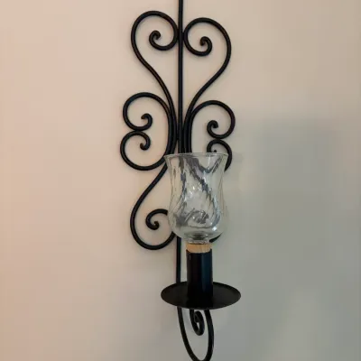 Sale Photo Thumbnail #64: Vintage black wrought iron wall sconce featuring scrollwork details and a clear, swirled glass hurricane shade.