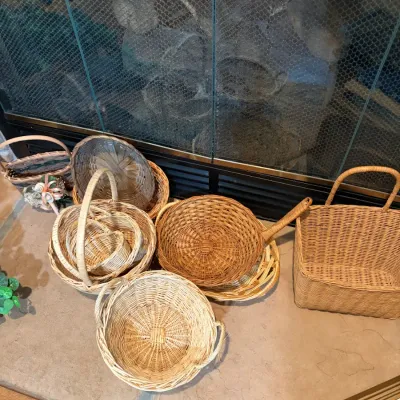 Sale Photo Thumbnail #45: Collection of vintage woven wicker baskets in various shapes and sizes, including nesting round baskets and a rectangular basket with a handle.