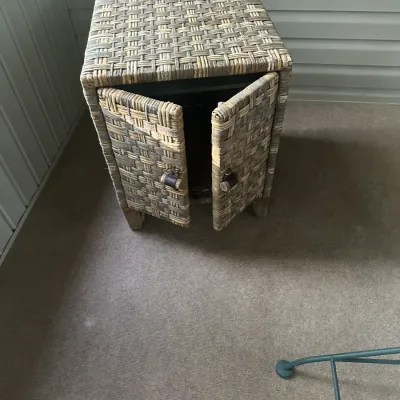 Sale Photo Thumbnail #106: Woven wicker side cabinet with two doors, featuring a multi-toned brown and grey weave and small wooden legs.
