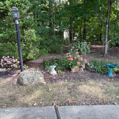 Sale Photo Thumbnail #34: Assorted garden decor including a black metal lamppost, potted pink geraniums, a small concrete sundial, and a teal ceramic birdbath.