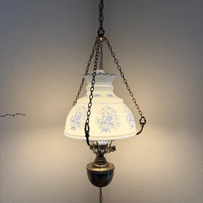 Sale Photo Thumbnail #43: Vintage Victorian-style hanging library lamp featuring a white milk glass shade with blue floral transfer designs and brass chain hardware.
