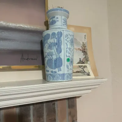 Sale Photo Thumbnail #104: Vintage Chinese-style blue and white porcelain vase featuring hand-painted lotus and floral designs, displayed on a white mantelpiece.