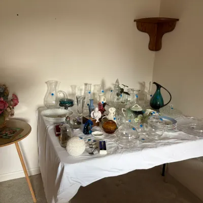 Sale Photo Thumbnail #14: Collection of vintage glassware and decorative collectibles, featuring a teal art glass pitcher, clear glass pitchers and bowls, and small figurines.