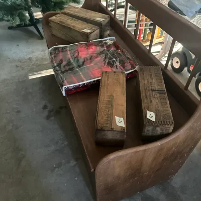 Sale Photo Thumbnail #113: Vintage wooden entry bench with a spindle back, displaying four rustic wooden cheese boxes and a packaged red plaid blanket.