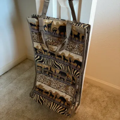 Sale Photo Thumbnail #44: Large tapestry tote bag featuring an African safari motif with animal silhouettes and prints, complete with adjustable shoulder strap and carrying handles.