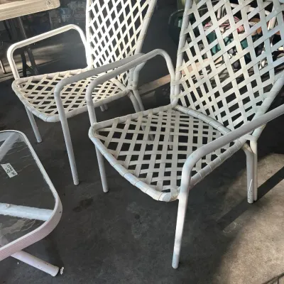 Sale Photo Thumbnail #111: Pair of vintage white vinyl strap patio armchairs with a matching glass-top side table, showing some wear from outdoor use.