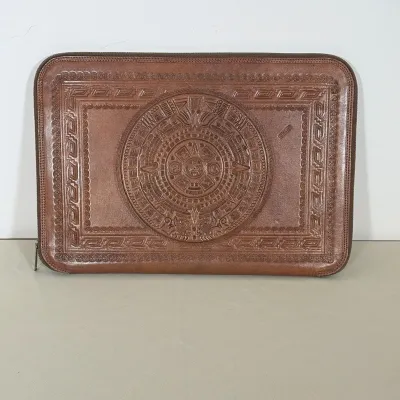 MEXICAN HAND TOOLED LEATHER ZIPPERED FILE CASE WITH AZTEC MOTIFS
This brown leather file case features a hand-tooled Aztec Sun Stone on...