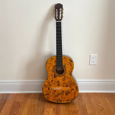 TAKAMINE G-124S CLASSICAL GUITAR WITH MULTIPLE ARTIST SIGNATURES
A Takamine G-124S acoustic classical guitar featuring a natural finish...
