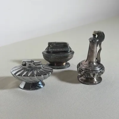 (3pc) THREE RONSON SILVER PLATED VINTAGE TABLE LIGHTERS
This lot features three Ronson silver-plated table lighters including the...