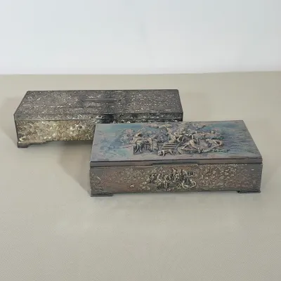 PAIR OF VINTAGE SILVER PLATED REPOUSSÉ BOXES
One box features an all-over floral scrollwork motif with a tan fabric-lined interior...