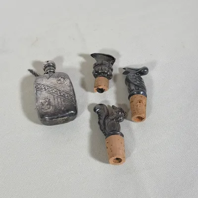 (4pc) STERLING SILVER NEOCLASSICAL STYLE FLASK AND THREE SILVER PLATED BOTTLE STOPPERS
Rectangular sterling silver flask features...