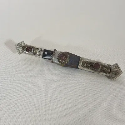 TIBETAN SILVERED METAL AND CARNELIAN INSET DAGGER WITH SCABBARD
This dagger features a steel blade and a hilt constructed of dark wood...
