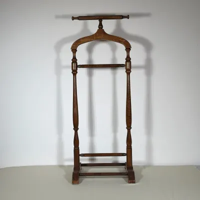 TRADITIONAL TURNED WOOD BUTLER VALET STAND
This stained wood valet stand features a curved top rail designed as a clothing hanger above a...