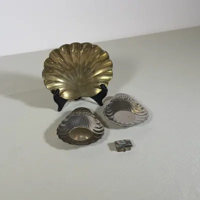 (4pc) SILVER PLATED AND BRASS SHELL-FORM DISHES AND STERLING SILVER PILL BOX
This lot features one large brass shell-form dish measuring...