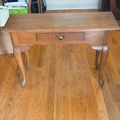QUEEN ANNE STYLE OAK CONSOLE TABLE
This console table features a rectangular top with an overhanging edge and a single frieze drawer. The...