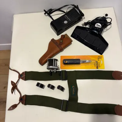 Sale Photo Thumbnail #287: Putter return, leather gun holster, suspenders, knife, sight mounts, hand radio, fishing reel