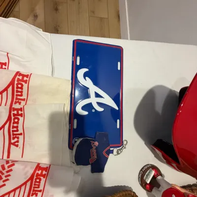 Sale Photo Thumbnail #213: Signed RedHawks Batting Helmet, Twins Homer Hanky (x4), 2 right handed baseball mitts, RedHawks gnome, Atlanta Braves license plate
