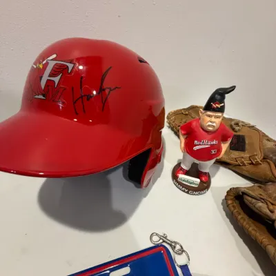 Sale Photo Thumbnail #214: Signed RedHawks Batting Helmet, Twins Homer Hanky (x4), 2 right handed baseball mitts, RedHawks gnome, Atlanta Braves license plate