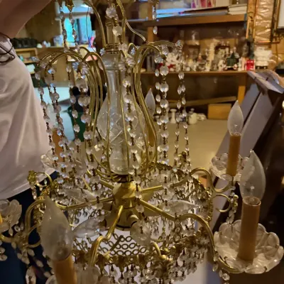 Vintage brass chandelier featuring cascading crystal bead strands and candle-style lights