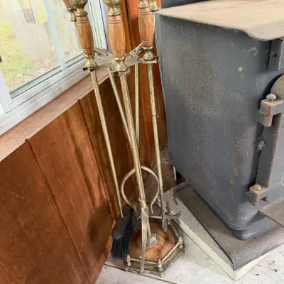 Vintage brass and wood-handled fireplace tool set featuring a matching hexagonal base stand
