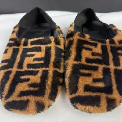  Fendi FF Logo Shearling Slippers crafted with genuine shearling featuring the classic tobacco-and-b