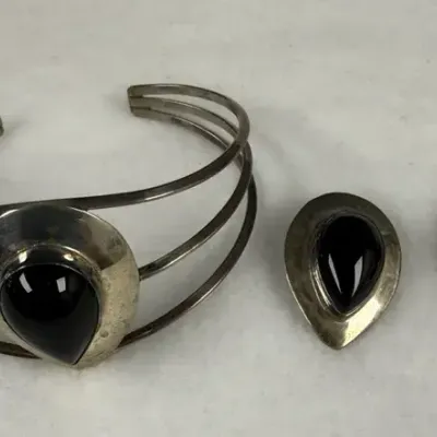 Vintage sterling silver and black onyx jewelry set featuring a triple-band cuff bracelet and matchin