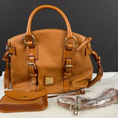 Dooney & Bourke Pebble Grain Bristol Satchel in a warm caramel or chestnut shade, featuring distinct
