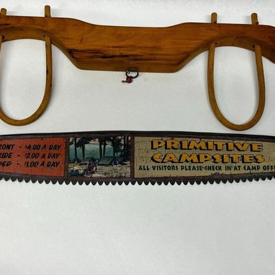 A Pair of Rustic Decorative Items Comprising a Painted Two-Man Crosscut Saw and a Wooden Ox Yoke