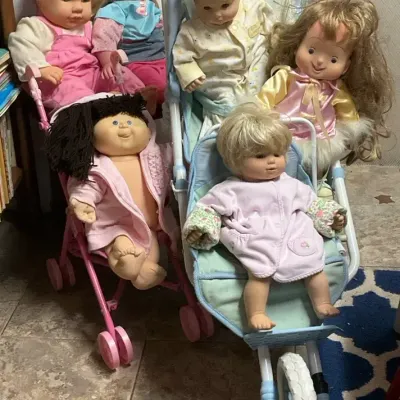 Baby Dolls Including a Cabbage Patch kids Doll With two Strollers And Clothes