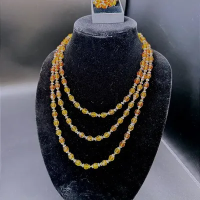 A 32" Continuous Strand Of Orange Colored Beads And A Pair Of Citrine Colored Clip-On Earrings