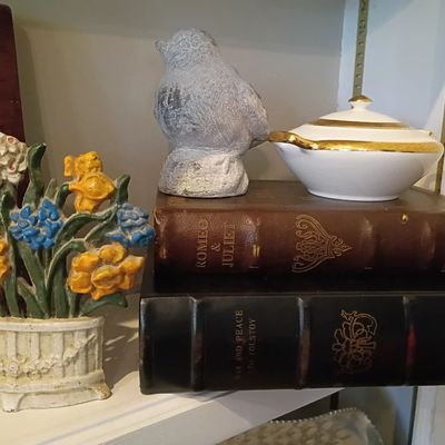 Cast iron flower basket doorstop, antique books, ceramic bird
