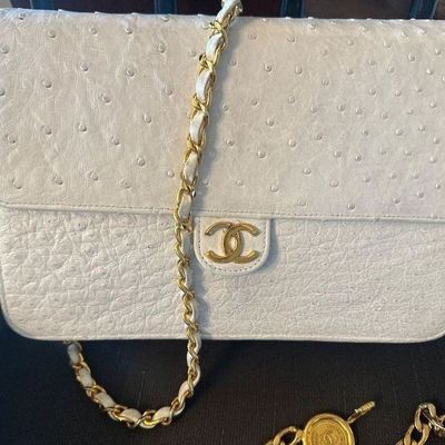 Vintage Chanel white ostrich leather flap bag featuring a gold-tone CC turn-lock closure and woven chain strap.