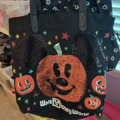 Walt Disney World Halloween tote bag featuring a sequined Mickey Mouse jack-o'-lantern design on black canvas with faux leather straps.