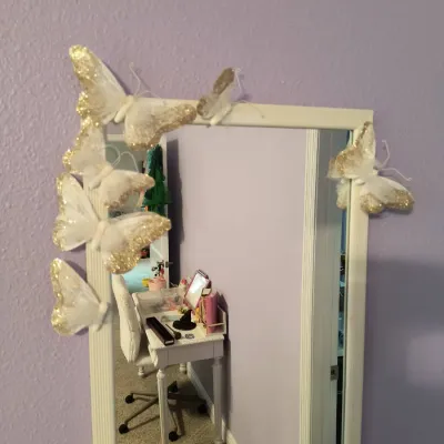 Rectangular wall mirror with a white frame, decorated with gold glitter-accented butterfly ornaments.
