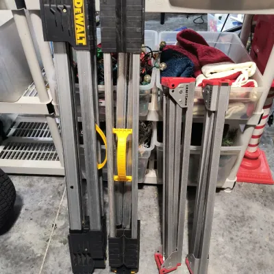 Two DeWalt folding sawhorses and two Craftsman folding sawhorses, showing some light wear from use.