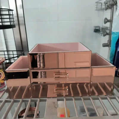 Rose gold mirrored vanity organizer with two drawers and three open compartments, featuring a pink interior lining.