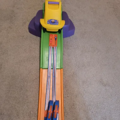 Step2 Up & Down Roller Coaster toy featuring a yellow ride-on car, green and orange track sections, and purple steps, showing light...