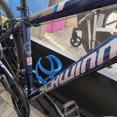 Schwinn Trailway hybrid bicycle featuring a dark blue aluminum frame, a blue Bontrager water bottle cage, and multi-speed gearing.