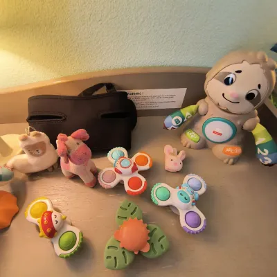 Collection of infant and toddler toys, including a Fisher-Price Linkimals Smooth Moves Sloth, suction cup spinner toys, and small plush...