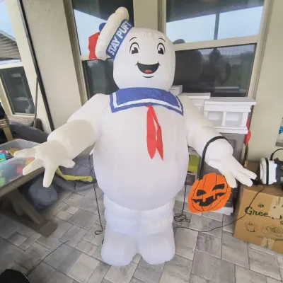Inflatable Stay Puft Marshmallow Man Halloween decoration holding a jack-o'-lantern bucket, in gently used condition.