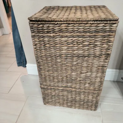 Woven seagrass laundry hamper with a matching hinged lid, showing a natural brown finish.
